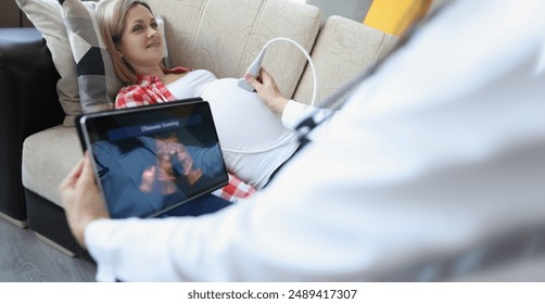 Close-up of gynecologist doing ultrasound scan on belly using modern digital ultrasound machine with tablet. Female patient expecting pregnancy. Gynecology concept - Powered by Shutterstock