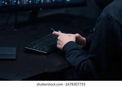 Close-up of the hacker's hands coding on smartphone with broken screen, typing program code on the keyboard.