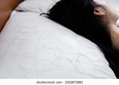 closeup hair loss fallen on pillow with blur background of woman sleeping in bed  - Shutterstock ID 2202872881