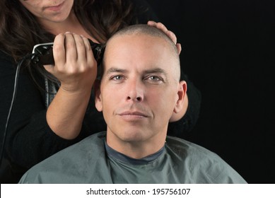 Close-up Of A Hair Stylist Using Clippers To Shave Her Clients Head.