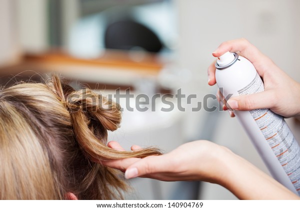 美容院のお客の髪にヘアスプレーを使った手の接写 の写真素材 今すぐ編集