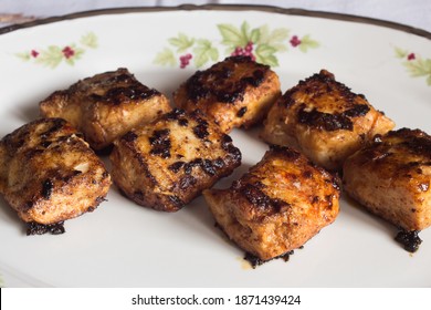 Close-up Of Hake Loins In Butter With Garlic And Paprika On A Decorated Old Plate. Food And Fish.