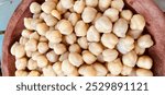 Close-up of half a wooden bowl filled with chickpeas or Cicer arietinum. Selective Focus. Copy Space. Background.