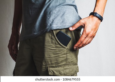 Close-up Of A Hand About To Take A Ringing Phone From A Pant Pocket