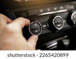 Closeup of hand adjusting the conditioner in a modern car. Dashboard with air flow, climate control and temperature button temperature button inside transport. Car HVAC System. Detail interior of car.