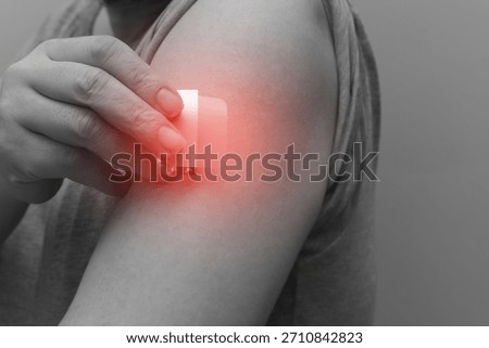 A close-up of a hand applying a nicotine patch to the upper arm. Represents Nicotine Replacement Therapy (NRT) and the user's commitment to quit smoking and pursue better health
