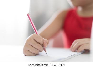 Closeup Hand Of Asian Child Or Kid Girl Writing Or Draw Learning And Doing Homework Or Person Learn From Home And Practicing Write By Wooden Pencil On Paper Book And Study Online From Back To School