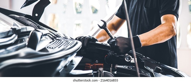 Close-up hand auto mechanic using the wrench to repairing car engine problem. Concepts of check and fix car and maintenance servicing.