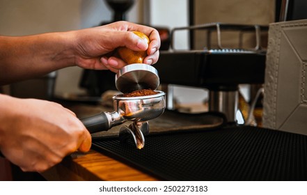 Close-up of hand Barista cafe making coffee with manual presses ground coffee using tamper at the coffee shop - Powered by Shutterstock