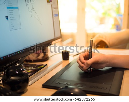 closeup hand of a boy Drawing tablet and Pen on a computer
