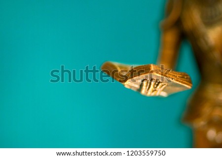 Closeup of the hand of a bronze statue holding an open book.  Sculpture closeup. Small depth of field