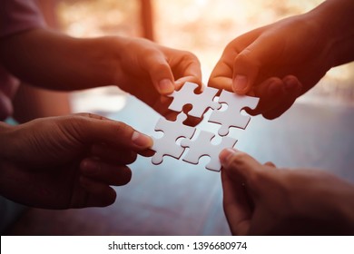 Closeup hand of business people connecting jigsaw puzzle with sunlight effect, Business solutions and represent team support and help concept, success and strategy concept - Shutterstock ID 1396680974