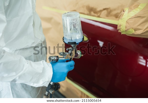 Close-up of the hand of a car painter with spray gun\
in his hand