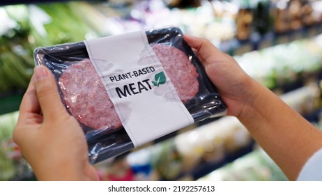 Close-up hand carry choose zero pork soy bean faux peas cutlet gluten free read beyond non-meat lab label. Buy raw fake beef tray in asia store veggie burger patty for health care eat diet meal cook. - Shutterstock ID 2192257613