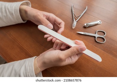 Close-up Of Hand Of Caucasian Young Woman Doing Manicure At Home With Nail Supplies.