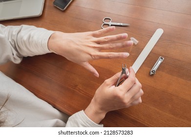 Close-up Of Hand Of Caucasian Young Woman Doing Manicure At Home With Nail Supplies.