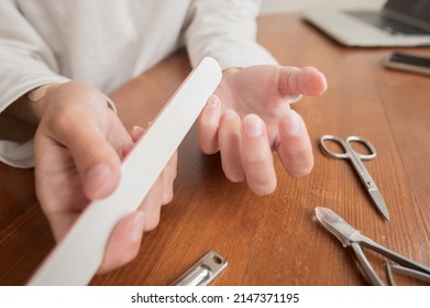 Close-up Of Hand Of Caucasian Young Woman Doing Manicure At Home With Nail Supplies.