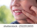 close-up hand of child, boy of 9 years old points new tooth fang in mouth with finger, concept of children