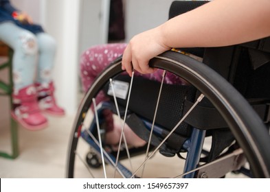 close-up hand of a child on a wheel from a wheelchair. Disabled children concept.