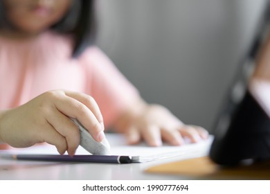 Closeup Hand Of Child Student Back To School Or Kid Girl Write Or Draw And Using Eraser To Erase Mistaken Word On Paper Book With Smartphone Or Tablet Pad Or People Learn From Home And Study Online