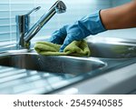 Close-up of hand cleaning kitchen sink