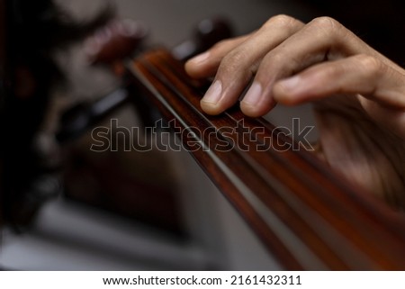 Close-up of the hand correctly placed in first position on the cello. Concept orchestra instrument and music student.
