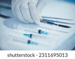 Closeup of hand, doctor and medical tools, scalpel and needle syringe for surgical procedure in healthcare. Medicine, health insurance and operation, surgeon person in hospital with clean instruments