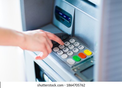 Closeup of hand entering PIN code into an ATM bank machine. 