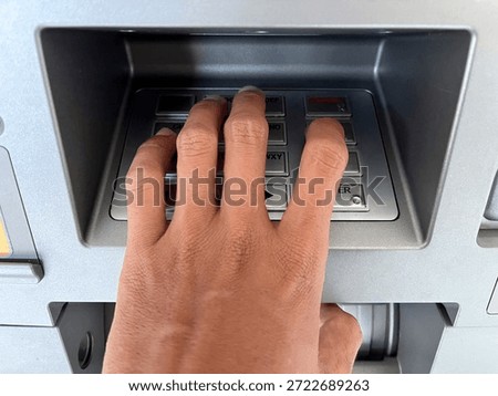 Close-up of a hand entering a PIN code on an ATM machine keypad