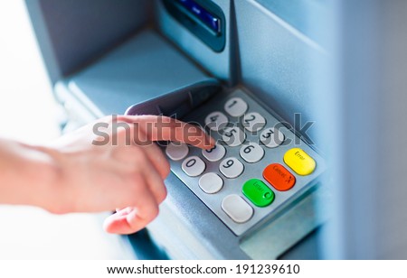 Close-up of hand entering PIN/pass code on ATM/bank machine keypad