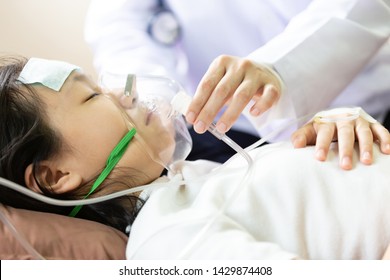 Closeup Of Hand Female Caregiver Holding Oxygen Mask With Cute Child Patient In Hospital Bed Or Home,little Girl Putting Inhalation,doctor Or Nurse Intensive Care,health Care,support,help Concept