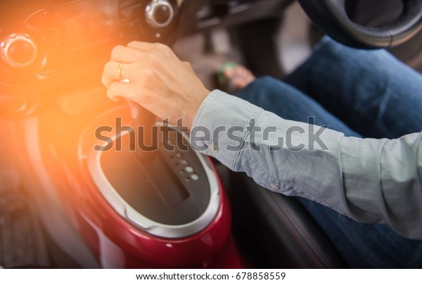 Closeup of hand gear\
stick driving car.
