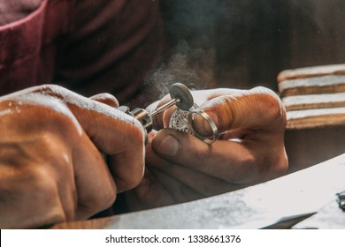 Close-up of a hand of a goldsmith who builds a precious jewel with valuable diamonds. To make the jewel it takes: precision, craftsmanship and patience. Concept of: gold, luxury. - Shutterstock ID 1338661376