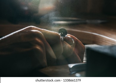 Close-up of a hand of a goldsmith who builds a precious jewel with valuable diamonds. To make the jewel it takes: precision, craftsmanship and patience. Concept of: gold, luxury. - Powered by Shutterstock