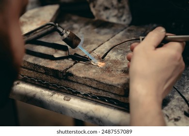 Close-up of a hand of a goldsmith who builds a precious jewel with valuable diamonds. To make the jewel it takes: precision, craftsmanship and patience. Concept of: gold, luxury. - Powered by Shutterstock