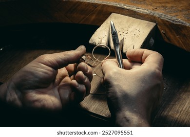 Close-up of a hand of a goldsmith who builds a precious jewel with valuable diamonds. To make the jewel it takes: precision, craftsmanship and patience. Concept of: gold, luxury. - Powered by Shutterstock