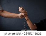 Close-up of hand holding kid hands with handcuffs, child was a victim of human trafficking, human rights violations, missing kidnapped, human trafficking concept