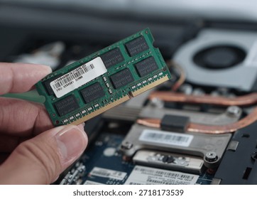 Close-up of a hand holding a memory module, displaying the FRU (Field Replaceable Unit) label. Useful for topics on part compatibility and authentic hardware replacement.