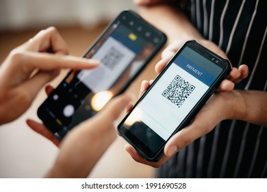 Closeup of a hand holding phone and scanning qr code. QR code payment and cash technology concept.