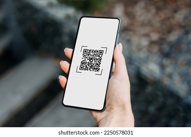 Closeup of a hand holding phone and scanning qr code. QR code payment and cash technology concept.