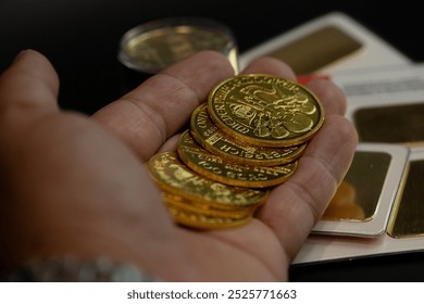 close-up hand holding real austrian golden coins. investments, savings, finances stock photo  - Powered by Shutterstock