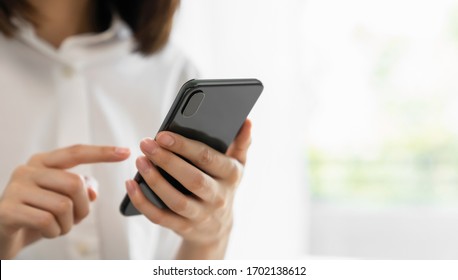 Close-up of hand holding smartphone device and  typing text message on online social.