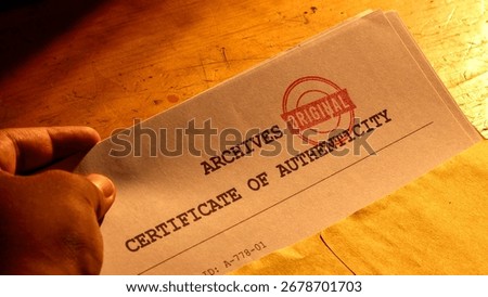 Close-up of a hand holding a stack of documents, likely a certificate of authenticity, with a red stamp that reads ORIGINAL visible