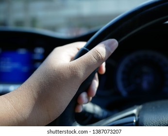 closeup of hand holding the steering wheel. 