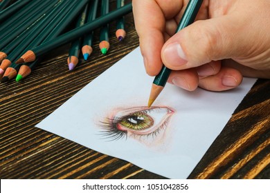 Close-up Hand Of Illustrator Drawing Realistic Eye On Paper With Pencils. 