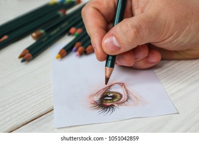 Close-up Hand Of Illustrator Drawing Realistic Eye On Paper With Pencils. 