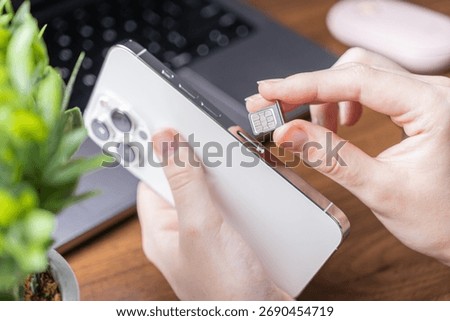 Close-up of a hand inserting a microchip SIM card into a sleek modern mobile phone, highlighting essential steps for network activation, cellular service, and digital life