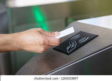 Close-up Hand With Keycard At Pedestrian Access Control Flap Barriers.