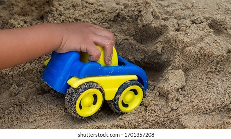 Closeup hand of little child boy playing car toy on sand outdoor in rural nature background. Happy kid enjoy in relaxing day, preschool learning ef concept. - Powered by Shutterstock