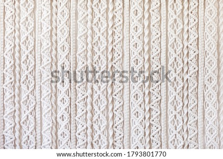 Close-up of hand made macrame texture pattern. ECO friendly modern knitting DIY natural decoration concept  in the interior. Flat lay. Handmade macrame 100% cotton. Female hobby.
